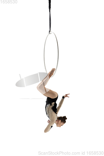 Image of Young female acrobat, circus athlete isolated on white studio background. Training perfect balanced in flight