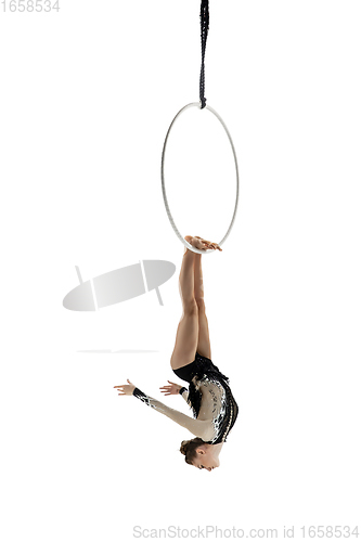 Image of Young female acrobat, circus athlete isolated on white studio background. Training perfect balanced in flight