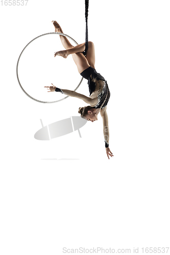 Image of Young female acrobat, circus athlete isolated on white studio background. Training perfect balanced in flight