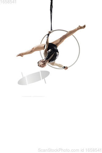 Image of Young female acrobat, circus athlete isolated on white studio background. Training perfect balanced in flight