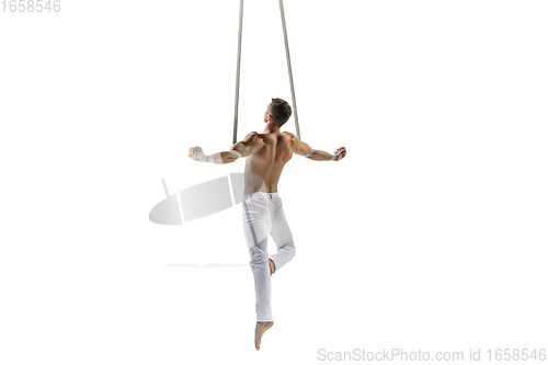 Image of Young male acrobat, circus athlete isolated on white studio background. Training perfect balanced in flight