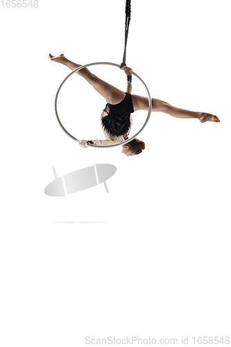 Image of Young female acrobat, circus athlete isolated on white studio background. Training perfect balanced in flight