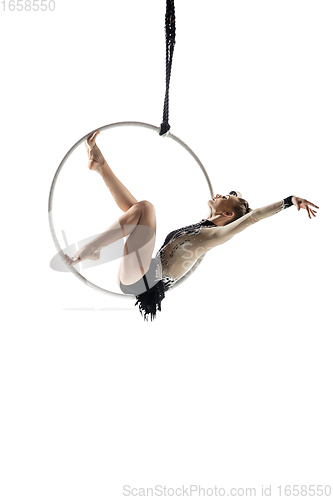 Image of Young female acrobat, circus athlete isolated on white studio background. Training perfect balanced in flight