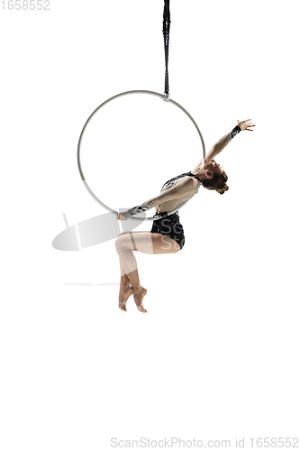 Image of Young female acrobat, circus athlete isolated on white studio background. Training perfect balanced in flight