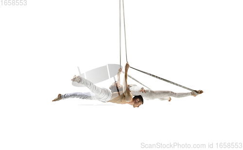 Image of Couple of young acrobats, circus athletes isolated on white studio background. Training perfect balanced in flight