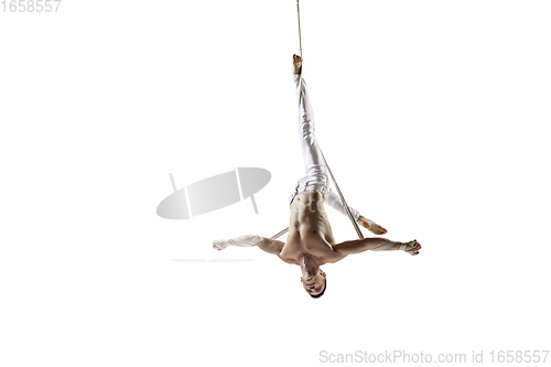 Image of Young male acrobat, circus athlete isolated on white studio background. Training perfect balanced in flight