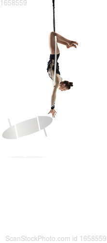 Image of Young female acrobat, circus athlete isolated on white studio background. Training perfect balanced in flight