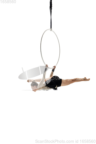 Image of Young female acrobat, circus athlete isolated on white studio background. Training perfect balanced in flight