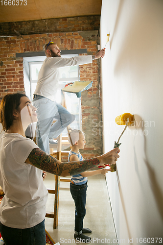 Image of Young family doing apartment repair together themselves. Mother, father and son doing home makeover or renovation