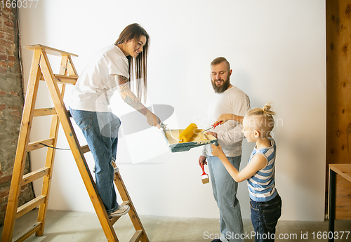 Image of Young family doing apartment repair together themselves. Mother, father and son doing home makeover or renovation