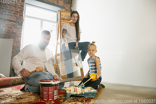 Image of Young family doing apartment repair together themselves. Mother, father and son doing home makeover or renovation