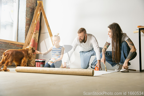 Image of Young family doing apartment repair together themselves. Mother, father and son doing home makeover or renovation