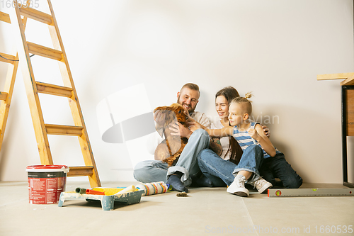 Image of Young family doing apartment repair together themselves. Mother, father and son doing home makeover or renovation