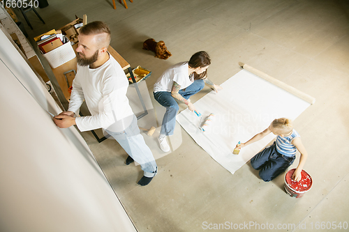 Image of Young family doing apartment repair together themselves. Mother, father and son doing home makeover or renovation