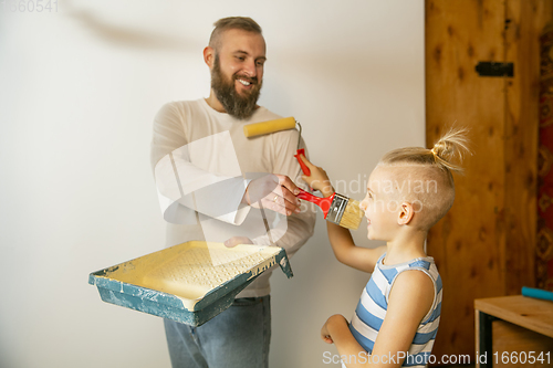 Image of Young family doing apartment repair together themselves. Happy father and son doing home makeover or renovation