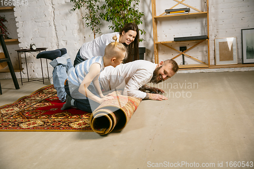 Image of Young family doing apartment repair together themselves. Mother, father and son doing home makeover or renovation