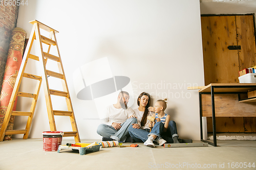 Image of Young family doing apartment repair together themselves. Mother, father and son doing home makeover or renovation