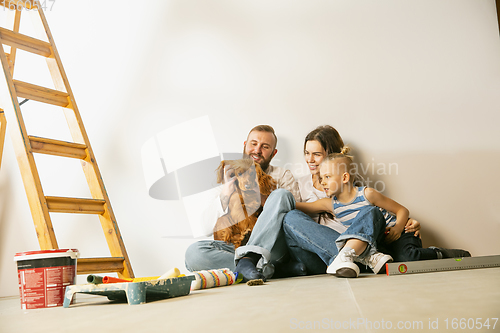 Image of Young family doing apartment repair together themselves. Mother, father and son doing home makeover or renovation