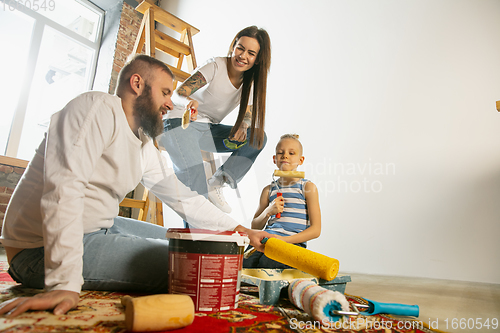 Image of Young family doing apartment repair together themselves. Mother, father and son doing home makeover or renovation