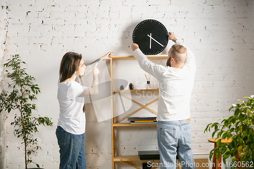 Image of Young family doing apartment repair together themselves. Married man and woman doing home makeover or renovation