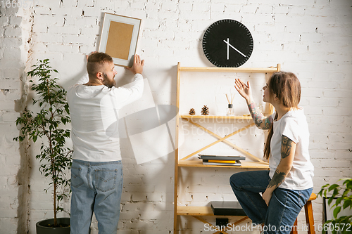 Image of Young family doing apartment repair together themselves. Married man and woman doing home makeover or renovation