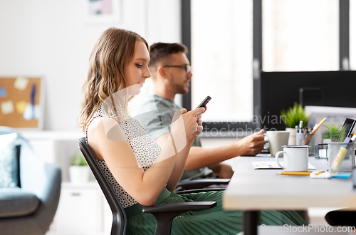 Image of businesswoman using smartphone at office