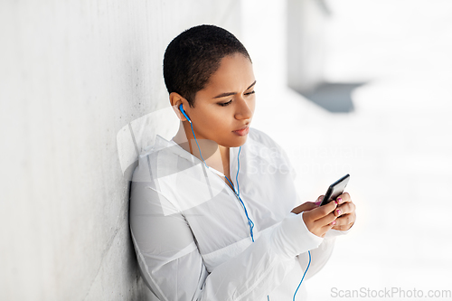 Image of african american woman with earphones and phone