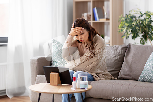 Image of sick woman having video call on tablet pc at home