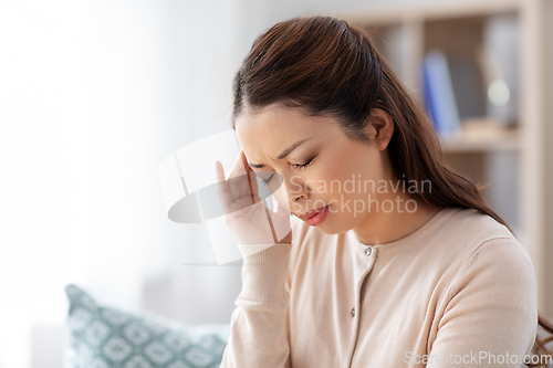 Image of sick asian woman having headache at home