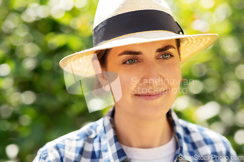 Image of portrait of woman in straw hat at summer garden