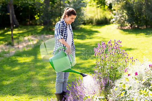 Image of young woman watering flowers at garden