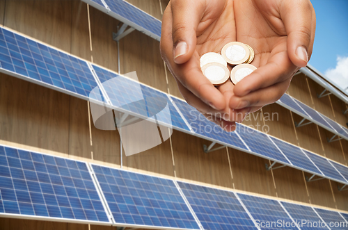 Image of hands holding money over solar panels