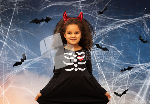 Image of girl in black dress and devil's horns on halloween