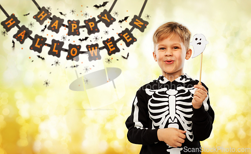 Image of boy in halloween costume with ghost decoration