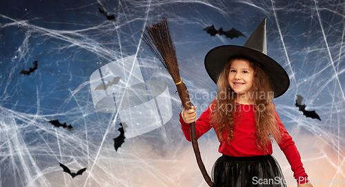 Image of girl in black witch hat with broom on halloween