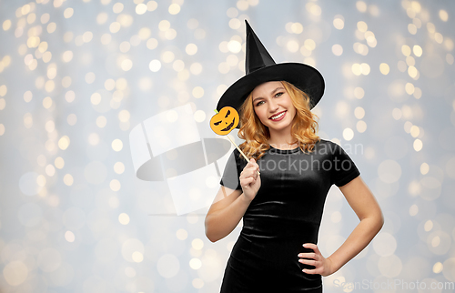 Image of woman in halloween costume of witch with pumpkin