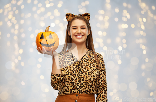 Image of woman in halloween costume of leopard with pumpkin