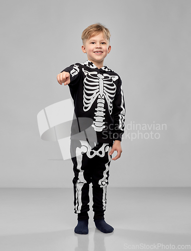 Image of boy in costume of skeleton pointing to camera