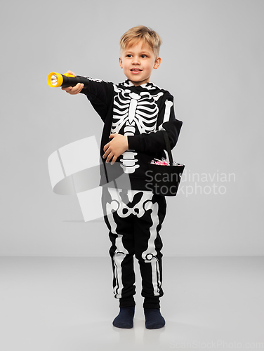 Image of boy with candies and flashlight on halloween