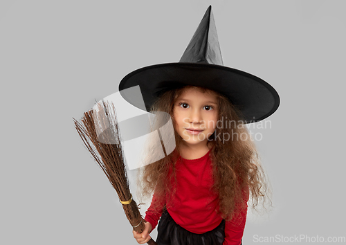 Image of girl in black witch hat with broom on halloween