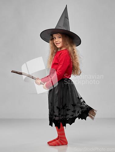 Image of girl in black witch hat with broom on halloween