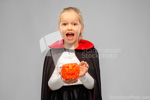 Image of girl in halloween costume of dracula with pumpkin