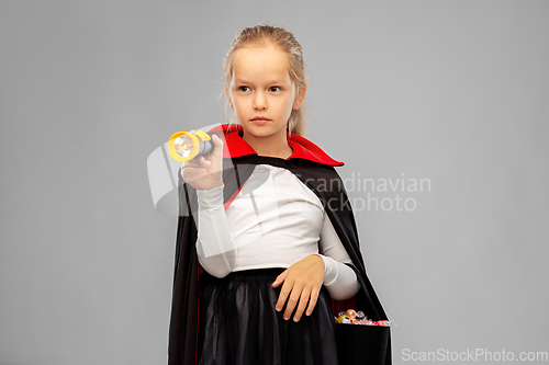 Image of girl in halloween costume of dracula with candies