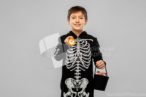 Image of boy in halloween costume with candies and torch