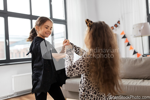 Image of girls in halloween costumes dancing at home