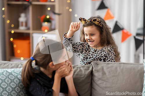 Image of girls in halloween costumes playing with spider