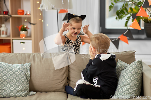 Image of kids in halloween costumes playing at home