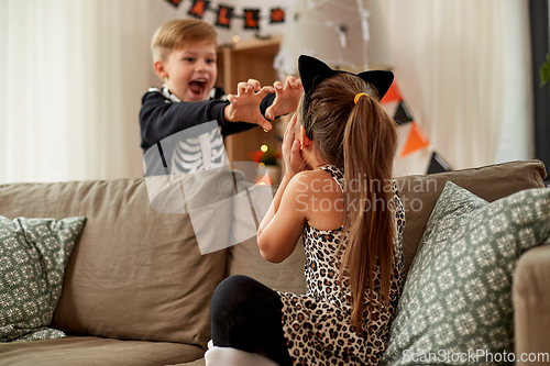 Image of kids in halloween costumes having fun at home