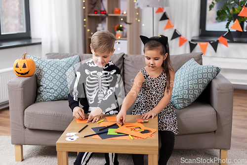 Image of kids in halloween costumes doing crafts at home