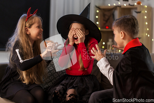 Image of kids in halloween costumes playing at home